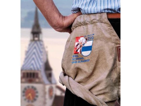 El cartel de fiesta ESAF 2019 Zug muestra un luchador, mirando encima de la torre de Zyt, al lago de Zuger .